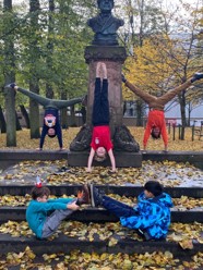 Divers holding handstands in-front of a statue