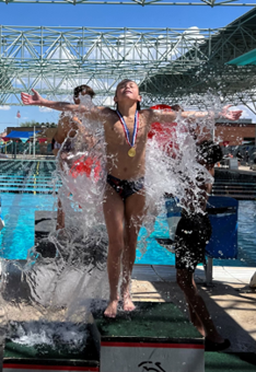 A diver on podium getting splashed by water 